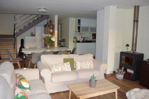 a living room with two white couches and a kitchen at Sobreomar in Bueu
