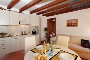 a kitchen and living room with a table and chairs at Residence Corte Grimani in Venice