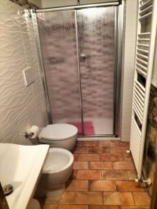 een badkamer met een toilet en een glazen douche bij Casetta di Ghino in Radicofani