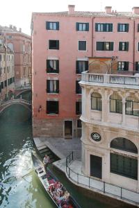 Una góndola viaja por un canal en una ciudad en Residence Corte Grimani en Venecia