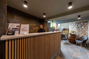 a woman standing behind a bar in a restaurant at Hotel Do Poduchy in Zawiercie