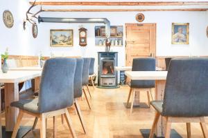 a dining room with blue chairs and a fireplace at Landhotel und Gasthof Kirchberger in Wildsteig