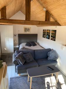 ein Wohnzimmer mit einem Sofa und einem Bett in der Unterkunft Stubbhuggets Lillstuga in Trosa