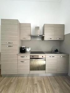 una cucina con armadietti in legno ed elettrodomestici in acciaio inossidabile di cas'Elisa a Cisternino