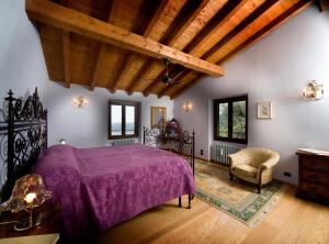 una camera con letto viola e sedia di Dimora Bolsone a Gardone Riviera