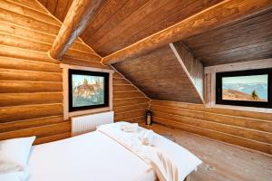 a bedroom with two beds and two windows at Poeme Chalet in Râșca