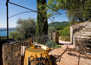 una mesa con un mantel amarillo en una terraza de madera en Dimora Bolsone en Gardone Riviera