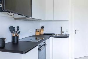 a kitchen with white cabinets and a sink at Haus Seeblick Wohnung 04 in Wohlenberg