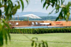 einen Pool mit Sonnenschirm und Stühlen in der Unterkunft Pool Villa Ana Residence in Gradac