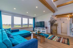 ein Wohnzimmer mit einem blauen Sofa und einem TV in der Unterkunft Pool Villa Ana Residence in Gradac