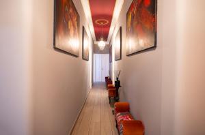 un couloir avec des chaises et des peintures sur les murs dans l'établissement Downtown Loulé, à Loulé
