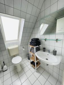 a white bathroom with a toilet and a sink at Exclusives Apartment im Herzen von Westerland in Westerland (Sylt)
