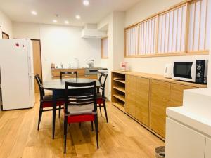 cocina con mesa, sillas y nevera en Yokohama HY House en Yokohama