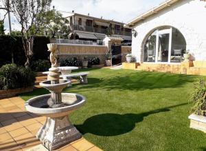 un jardín con una fuente en medio de un patio en Family House - La Mora Beach - Tarragona, en Tarragona