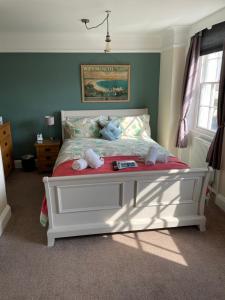 a bedroom with a white bed with stuffed animals on it at The Alendale Guesthouse in Weymouth