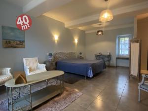 a bedroom with a bed and a couch and a table at Domaine Les Bertrands in Couches