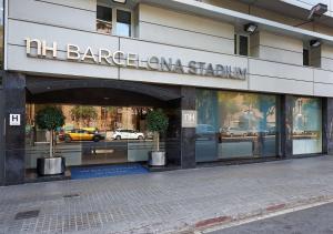a building with a sign on the front of it at NH Barcelona Stadium in Barcelona