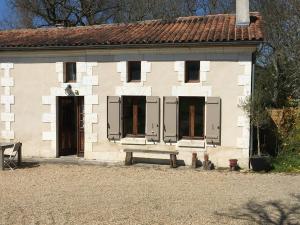 un bâtiment avec deux portes et un banc devant lui dans l'établissement Maison Périgord vert piscine et spa, à La Roche-Chalais