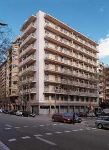 a large building with cars parked in front of it at NH Barcelona Les Corts in Barcelona