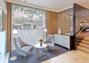 a living room with two chairs and a table at NH Barcelona Les Corts in Barcelona