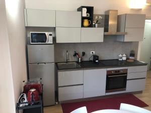 uma cozinha com armários brancos e um micro-ondas em Music House - Carozzi Apartments em Milão