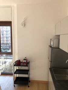a kitchen with a black refrigerator and a window at Music House - Carozzi Apartments in Milan