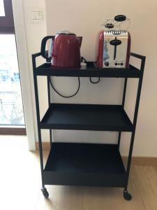 una estantería negra con tetera y una maleta. en Music House - Carozzi Apartments, en Milán