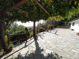 une terrasse en pierre avec une clôture et un arbre dans l'établissement Baita Sambuco, à Donato