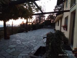 um pátio de pedra em frente a uma casa com o pôr-do-sol em Baita Sambuco em Donato