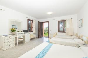 Hotel Genna 'e Masoni في كارديدو: غرفة نوم بسريرين ومكتب