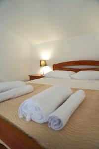 twee bedden met witte handdoeken in een slaapkamer bij Casa Horizonte in Nazaré