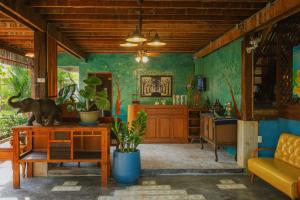 a living room with green walls and a wooden ceiling at Chiang Mai Las Orquideas Resort in Chiang Mai
