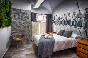 1 dormitorio con 1 cama y una pared con una foto en Apartamentos Gladiador, en Mérida
