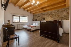 una camera da letto con due letti e un muro di pietra di Casa D'Augusta - Agroturismo a Miranda do Douro Altre 59 foto