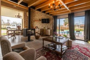 ein Wohnzimmer mit einem Sofa, einem TV und einem Tisch in der Unterkunft Casa D'Augusta - Agroturismo in Miranda do Douro