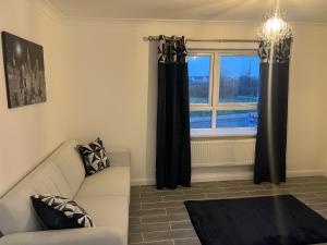 a living room with a couch and a window at Braemar Gardens in Dorney