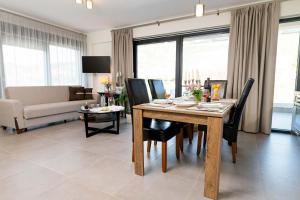 sala de estar con mesa de madera y sillas negras en Filos Suites, en Nea Iraklitsa
