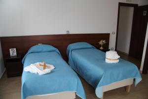 Dos camas con toallas y un pastel encima. en B&B IlGirasole, en Paravati