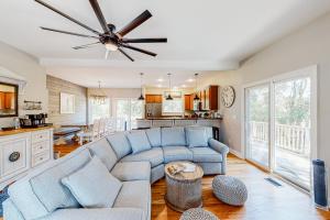 a living room with a couch and a ceiling fan at BlueDream in Kill Devil Hills