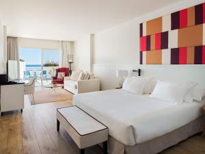 
a hotel room with a large bed and a large window at H10 Estepona Palace in Estepona

