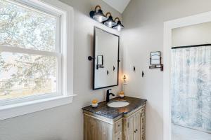 ein Badezimmer mit Waschbecken, Spiegel und Fenster in der Unterkunft BlueDream in Kill Devil Hills