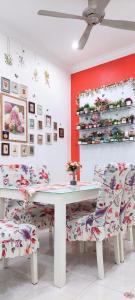 une salle à manger avec une table et des chaises blanches dans l'établissement The Floral Home, à Malacca