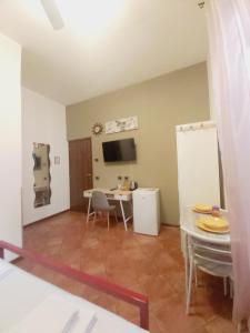 a living room with a table and chairs and a tv at LODGING 5 TERRE & PORTO LA SPEZIA in La Spezia