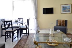 salon ze stołem, krzesłami i telewizorem w obiekcie Delmare Dion apartment w Salonikach