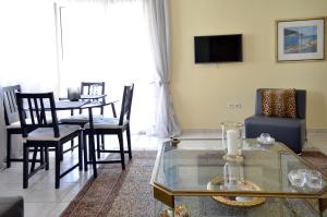 a living room with a table and chairs and a tv at Delmare Dion apartment in Thessaloniki