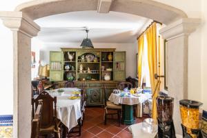 a dining room with two tables and an archway at Casa de S. Thiago do Castelo in Óbidos