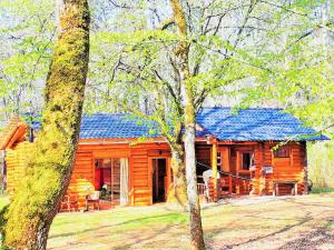 Les FargesMagnifique chalets en rondins avec ou sans spa et Tipis en plaine Nature Environnement ressourçant au calme vue imprenable Lascaux SPA non disponible juillet et aout的小木屋拥有蓝色的屋顶和树木