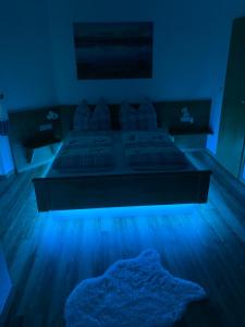 Habitación oscura con cama con luz azul en BERGWERK #nofilter, en Schwangau