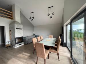 a dining room with a table and chairs and a fireplace at Dom nad jeziorem obok Uniejowa in Przykona