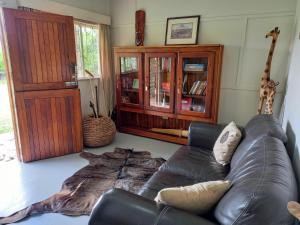 salon ze skórzaną kanapą i półką na książki w obiekcie Valhalla Ranch w mieście Dundee